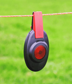 Patriot Black and red fence alert attached to a electric fence wire with a green background